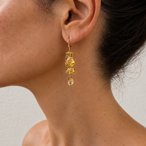 Almaza gold drop earring with yellow gemstones in varied cuts and a pear-shaped drop, worn on the ear.