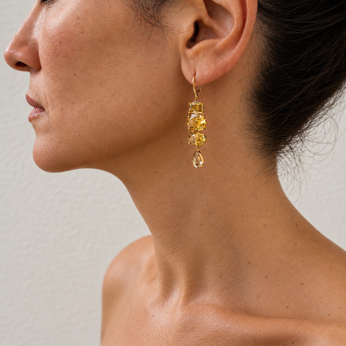 Almaza zircon drop earring in warm golden tones, worn on the ear with assorted gemstone shapes and a teardrop end.
