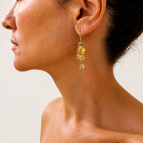 Almaza zircon drop earring worn on a model, showing a line of golden gemstones ending in a pale teardrop.