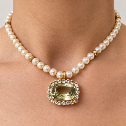 Amira olive green amethyst pendant with a white sapphire border, worn on a pearl necklace, front view.