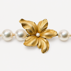 Close-up of the Beatrice choker flower, with five textured 18K gold petals and a small pearl centre between freshwater pearls.