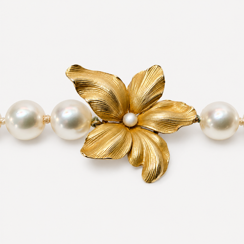 Close-up of the Beatrice choker flower, with five textured 18K gold petals and a small pearl centre between freshwater pearls.