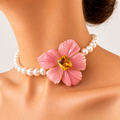 Bianca choker worn on a model, with a carved pink opal flower and golden citrine centre on a white pearl strand.