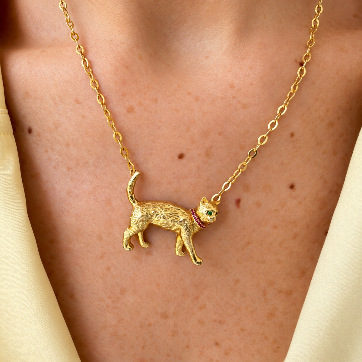 Charlie 18K gold cat necklace worn on a model, showing the cat pendant on an oval-link chain.