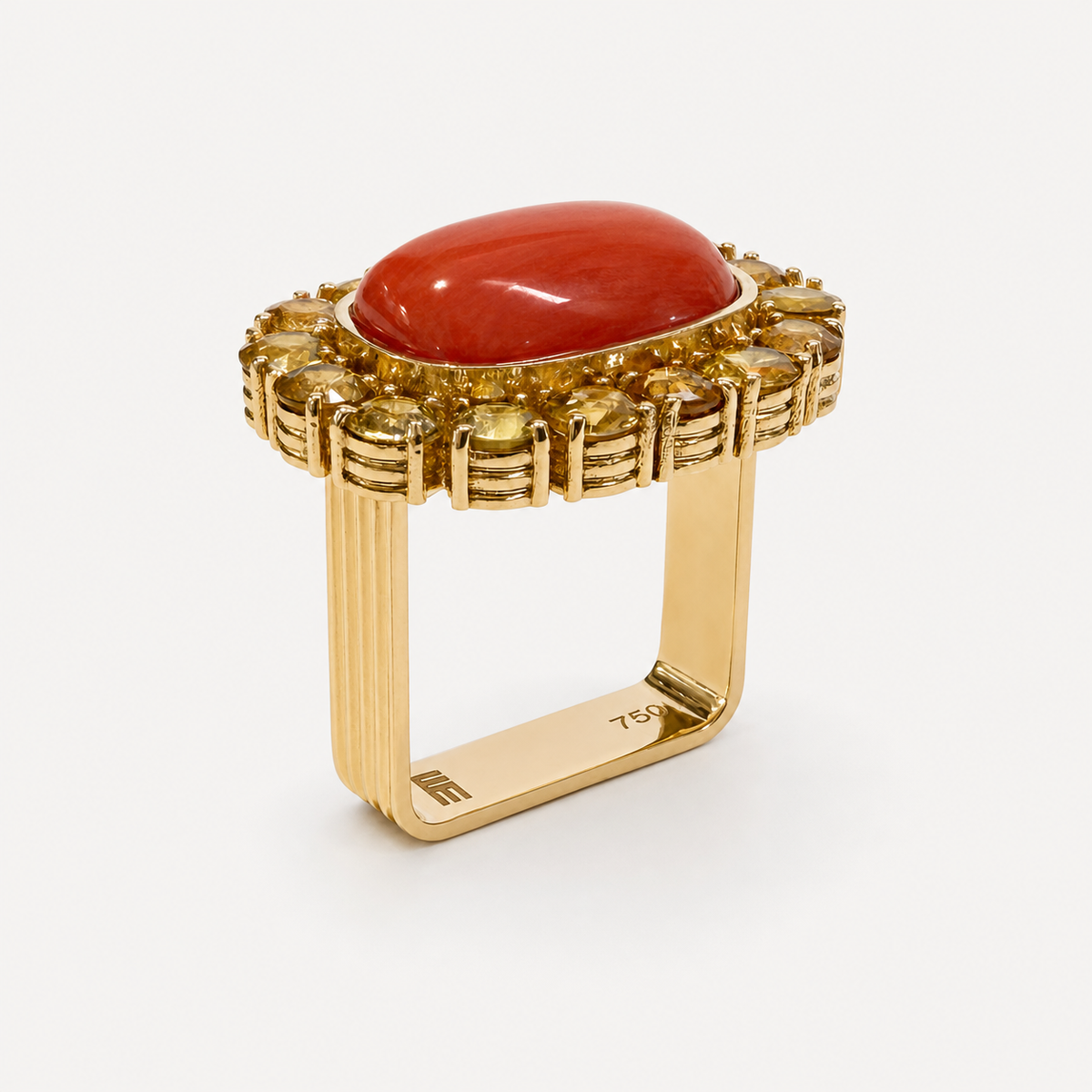 Side view of the Coralie coral and golden sapphire ring, showing the raised cabochon and square, fluted 18K gold band.