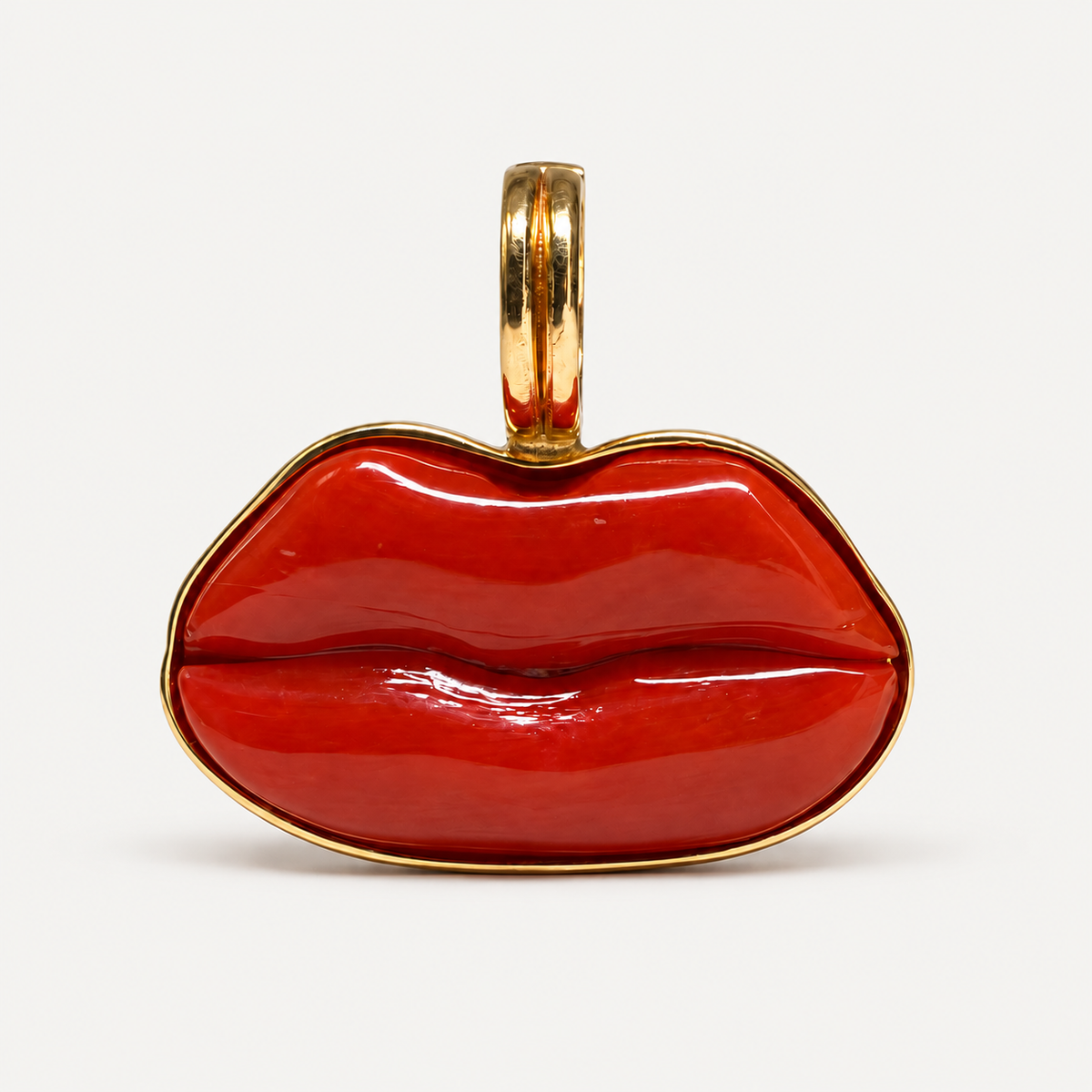 Front view of the Dina pendant, with hand-carved red Italian coral lips framed in polished 18K gold.