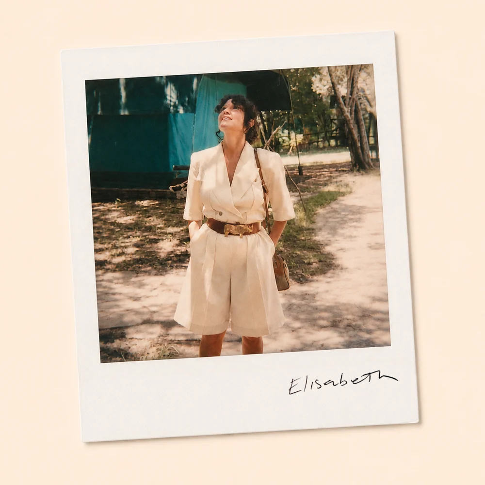 About Elisabeth Marques: a vintage photograph of Elisabeth, the studio’s namesake, in a cream outfit outdoors.