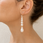 Farah freshwater pearl drop earring worn on a model, with a line of white pearls ending in a larger teardrop.