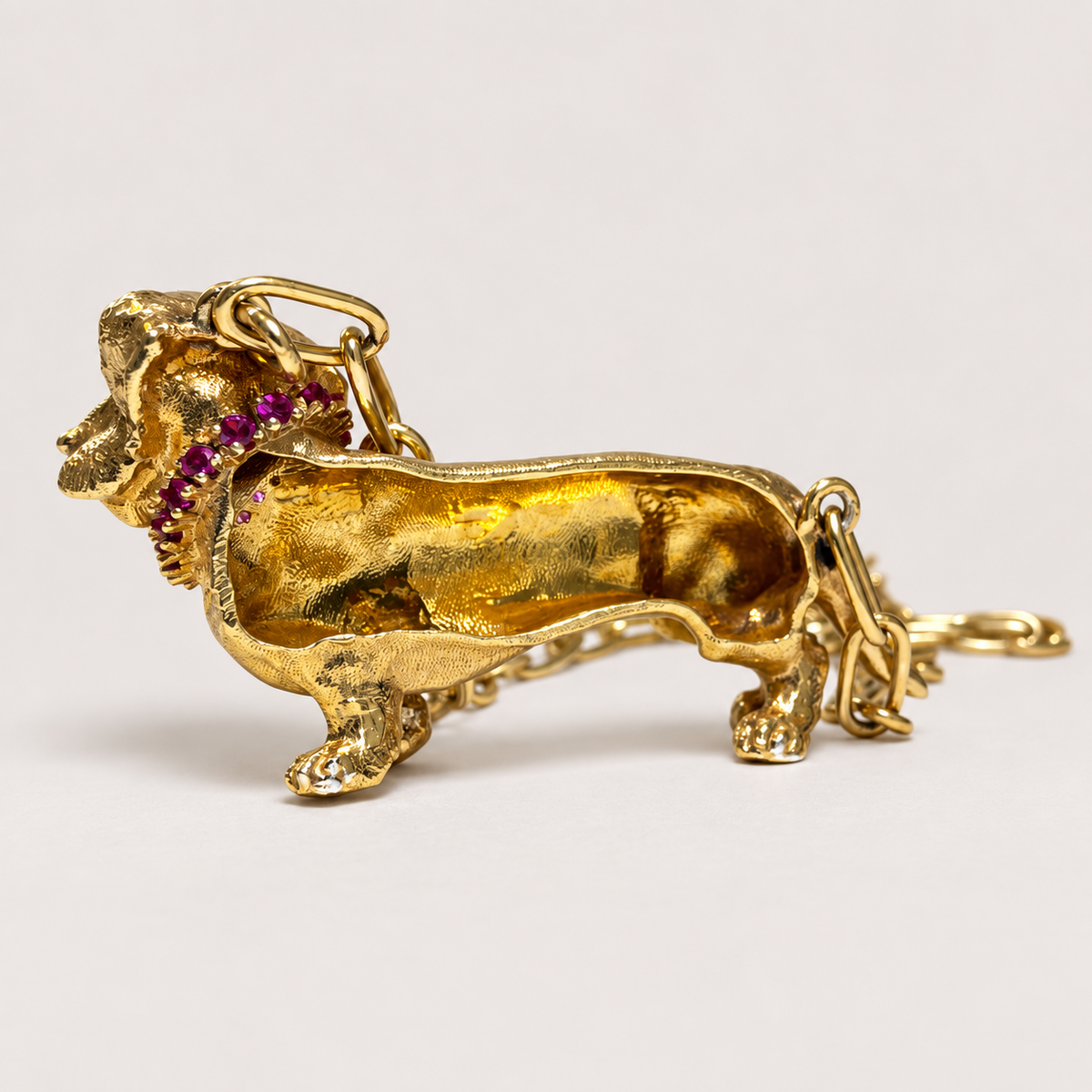 Reverse of the Gatsby 18K gold dachshund pendant, showing its hollow back and chain attachment loops.