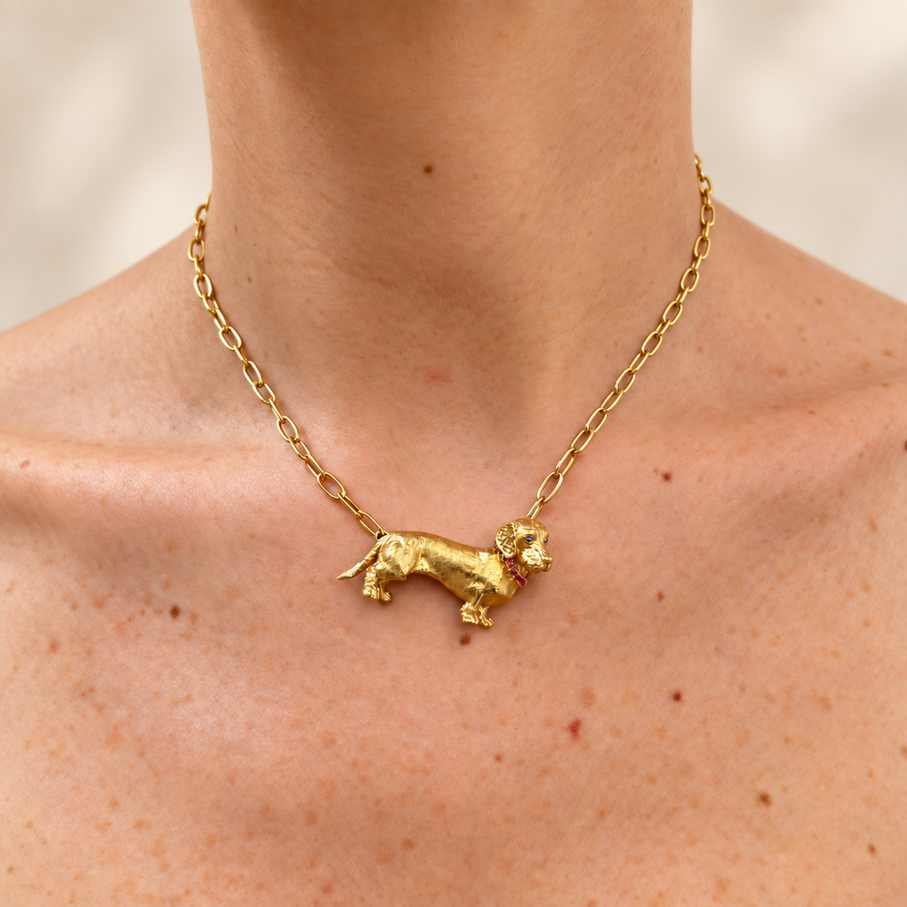 Gatsby 18K gold dachshund necklace worn on a model, showing the pendant on an oval-link chain.