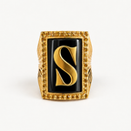Front view of the 18K gold initial S ring with black onyx and a golden sapphire halo.