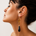 Lara 18K gold earring worn on a model, with golden citrines above a long faceted black onyx teardrop.