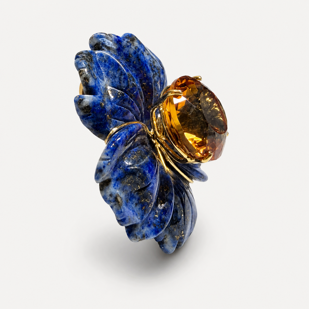 Side view of the Margo flower pendant, showing carved lapis lazuli petals and a raised citrine centre in gold.
