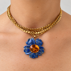 Margo blue lapis lazuli flower pendant with a citrine centre, worn on a gold chain, front view.