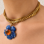 Angled close-up of the Margo lapis lazuli flower and citrine pendant worn on layered gold chains.