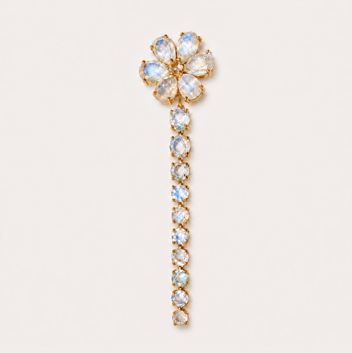 Full-length front view of the Nayla 18K gold earring, with a rainbow moonstone flower and a long graduated drop of round stones.