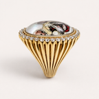 Side profile of the pet portrait ring, showing the domed rock crystal portrait, clear gemstone rim and tapering fluted gold shoulder.