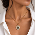 Pet portrait pendant worn on a gold chain, featuring an oval French bulldog portrait framed in gold.