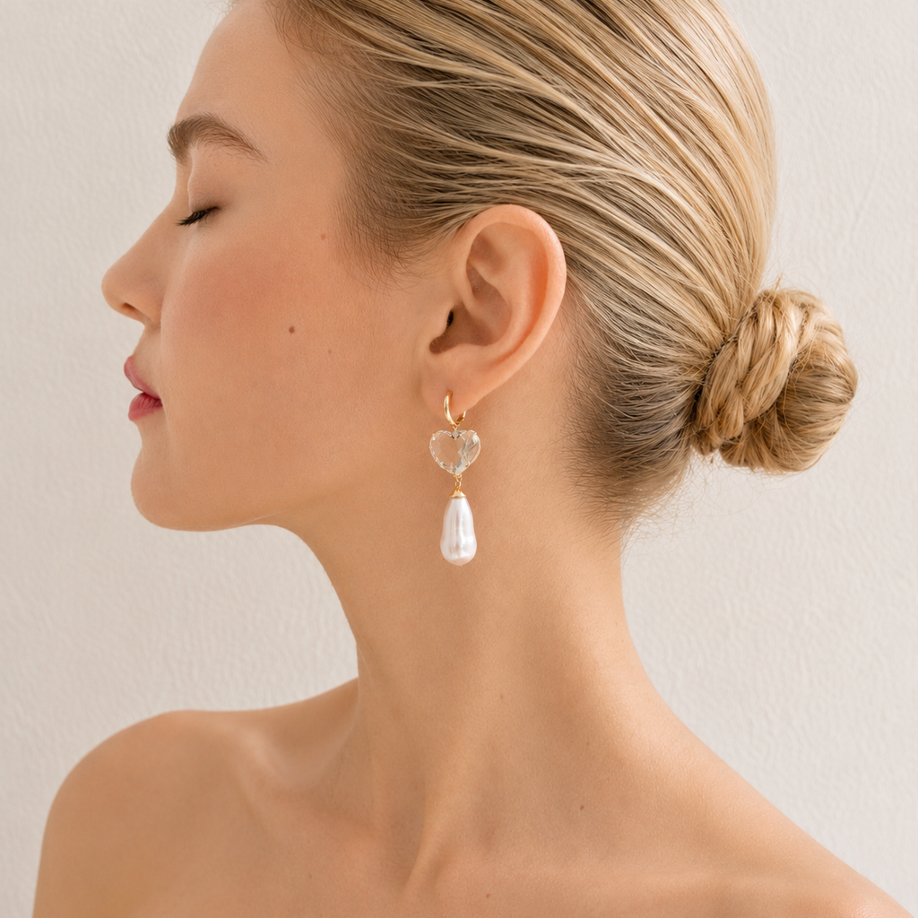 Sandy drop earring worn on a model, with a pale green heart-shaped gemstone and a long freshwater pearl beneath a gold hoop.
