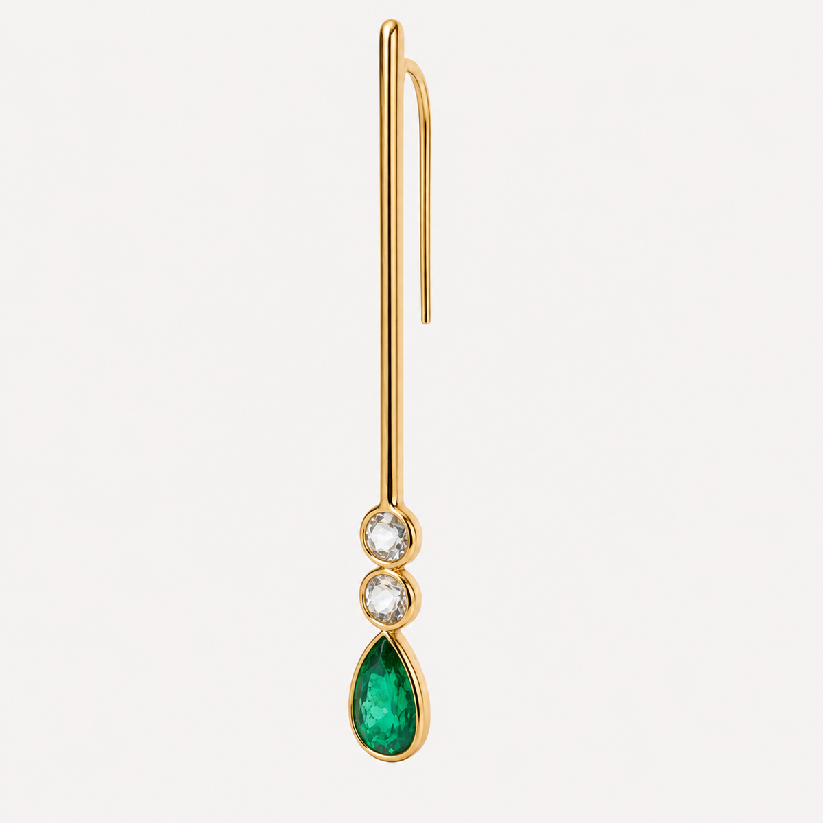 Angled view of the Serena emerald and aquamarine earring, showing the long gold hook behind the slender bar and bezel-set stones.