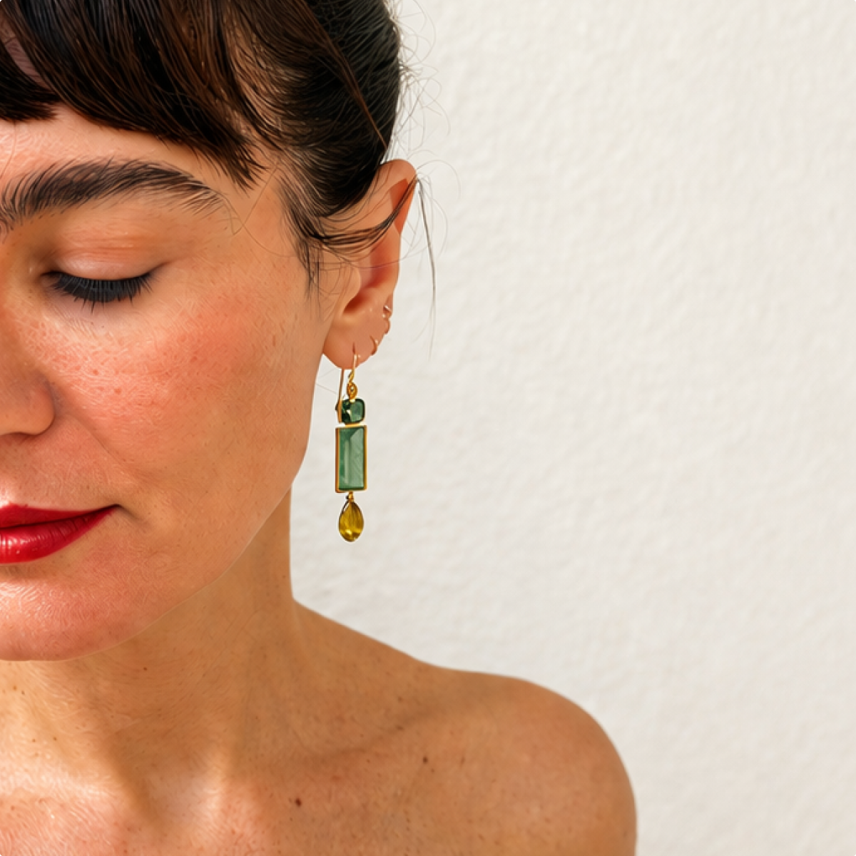 Souraya green fluorite and tourmaline drop earring worn on a model, with a rectangular centre and olive teardrop.