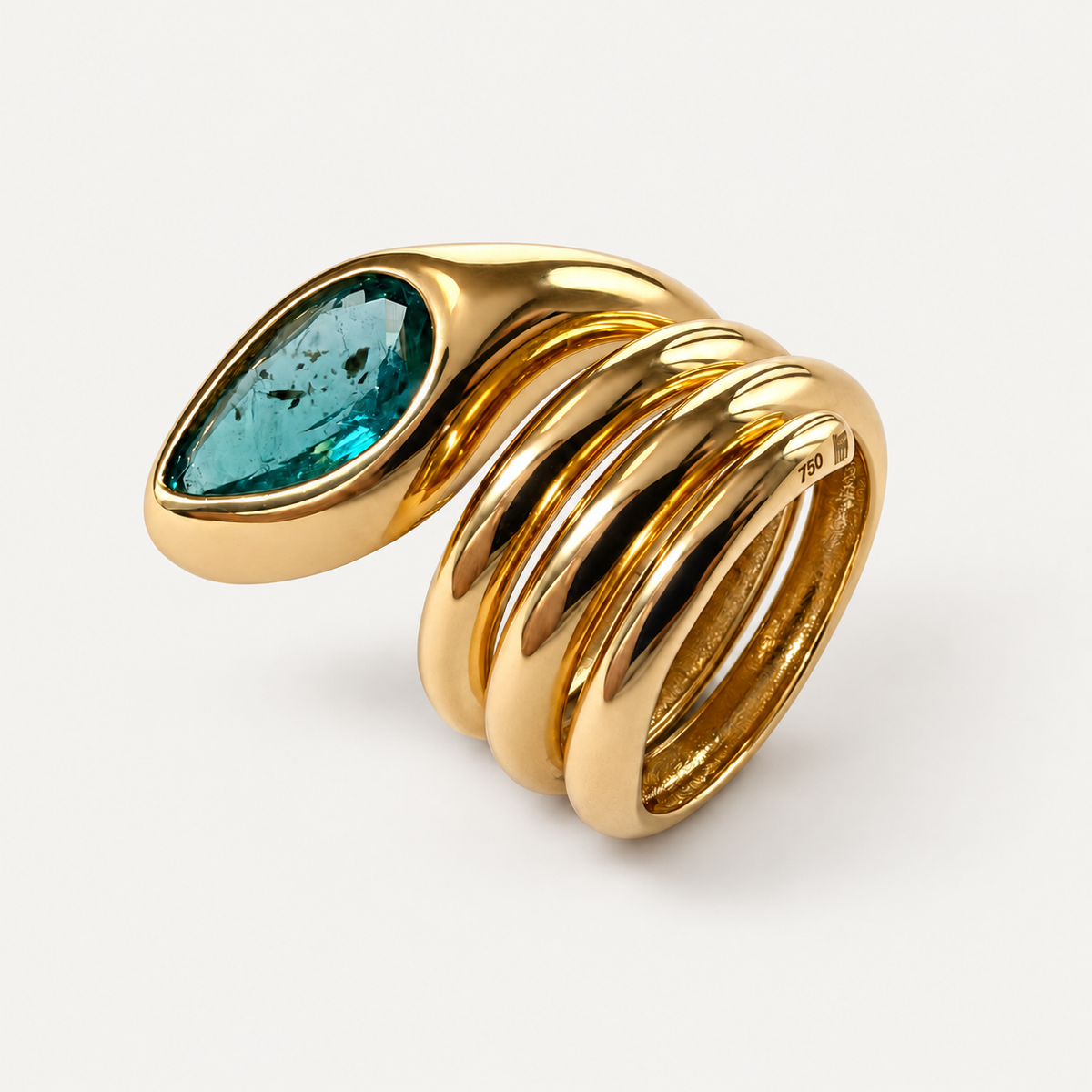 Angled side view of the Sylvie emerald snake ring, showing the rounded gold coils, inner band and pear-shaped stone.